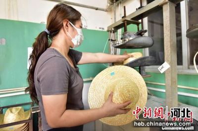 圖為青縣一家草編工藝品生產企業內,員工將草帽放入模具加熱定型。 尹向平 攝