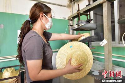 圖為青縣一家草編工藝品生產企業內,員工將草帽放入模具加熱定型。 尹向平 攝